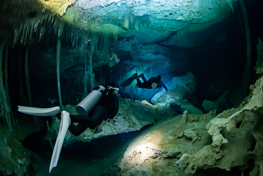 Diver in the foreground with white fins, second diver among columns, Quintana Roo, Mexico