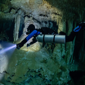 Sidemount diver close up lighting a white decorated cave wall, Quintana Roo, Mexico