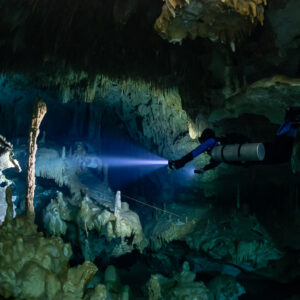 Sidemount diver beside a tall stalagmite column along the guideline, Quintana Roo, Mexico