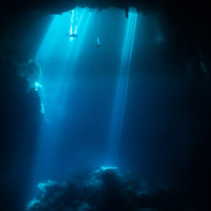 Vue verticale de rayons de soleil plongeant dans un cénote bleu profond, sans plongeur, Quintana Roo, Mexique