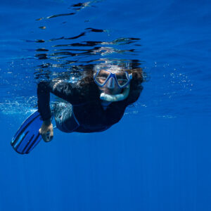 Woman snorkeler close to the surface, face and mask framed, Tahiti, Society Islands, French Polynesia