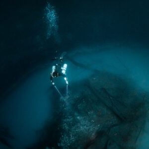 Diver seen from above over the edge of the sulfide cloud and debris, Cenote Angelita, Quintana Roo, Mexico