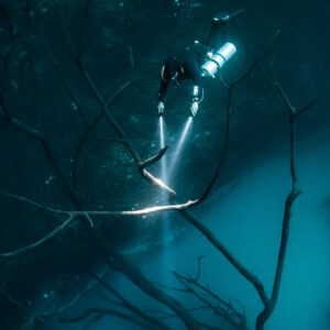 Diver lighting a glowing branch above the sulfide cloud, side angle, Cenote Angelita, Quintana Roo, Mexico