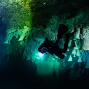 Diver silhouette in front of bell-shaped limestone formations, Cenote El Zapote, Quintana Roo, Mexico