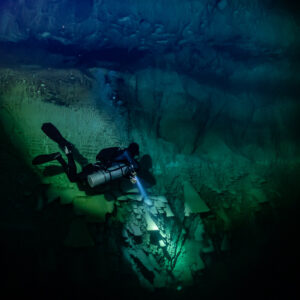 Diver lighting the base of bell formations, square frame, Cenote El Zapote, Quintana Roo, Mexico