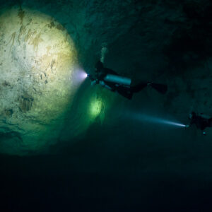 Two divers lighting a large circle on a cavern wall, Quintana Roo, Mexico