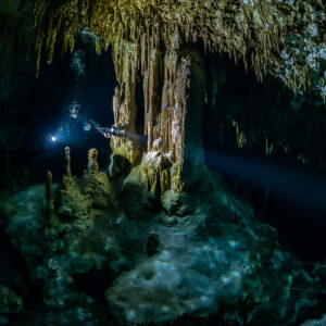 Two divers lighting a chamber of columns and stalagmites, Quintana Roo, Mexico