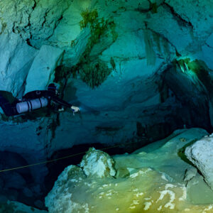Sidemount diver along a guideline in a blue limestone chamber, Quintana Roo, Mexico