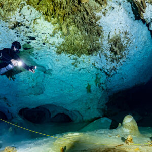 Sidemount diver over a pale floor in a blue limestone cavern, Quintana Roo, Mexico