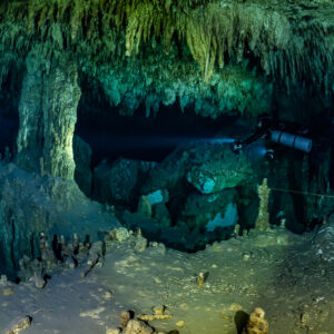 Sidemount diver passing a thick column in a decorated chamber, Quintana Roo, Mexico