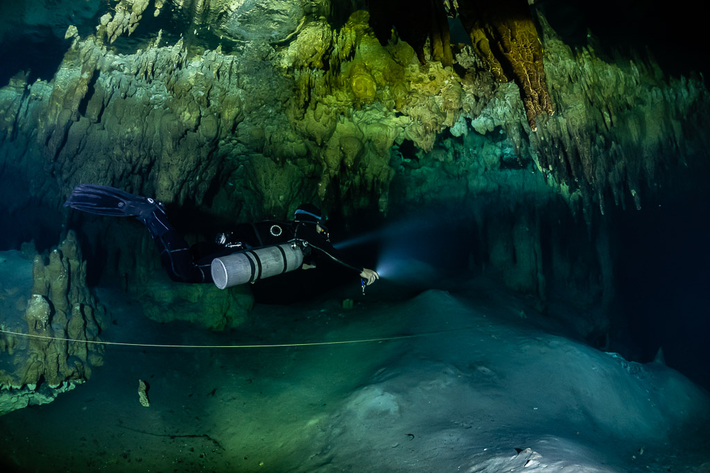 Plongeur en sidemount glissant au-dessus d’une pente claire près d’un fil d’Ariane, Quintana Roo, Mexique