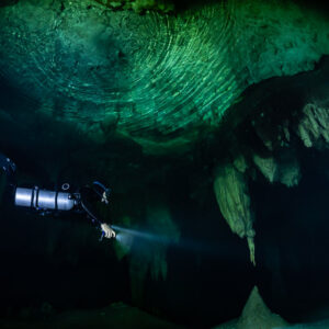 Sidemount diver below a banded green dome-shaped ceiling, Quintana Roo, Mexico