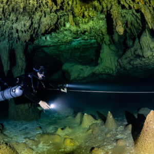 Sidemount diver along a guideline past a cone stalagmite, Quintana Roo, Mexico