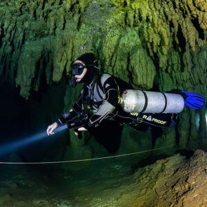 Sidemount diver close-up with torch along a guideline, second light behind, Quintana Roo, Mexico