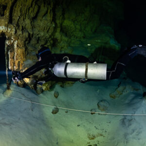 Sidemount diver stretched out along a guideline over pale sand, Quintana Roo, Mexico