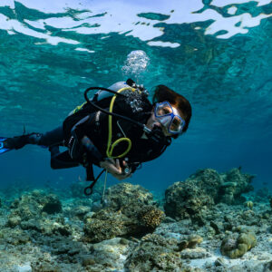 Woman diver close-up looking at camera in shallow water, Kuda Giri Wreck, Maldives