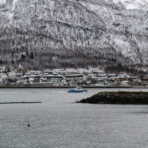 Ville saupoudrée de neige au pied d’une montagne boisée, avec digue, Tromsø, Troms, Norvège