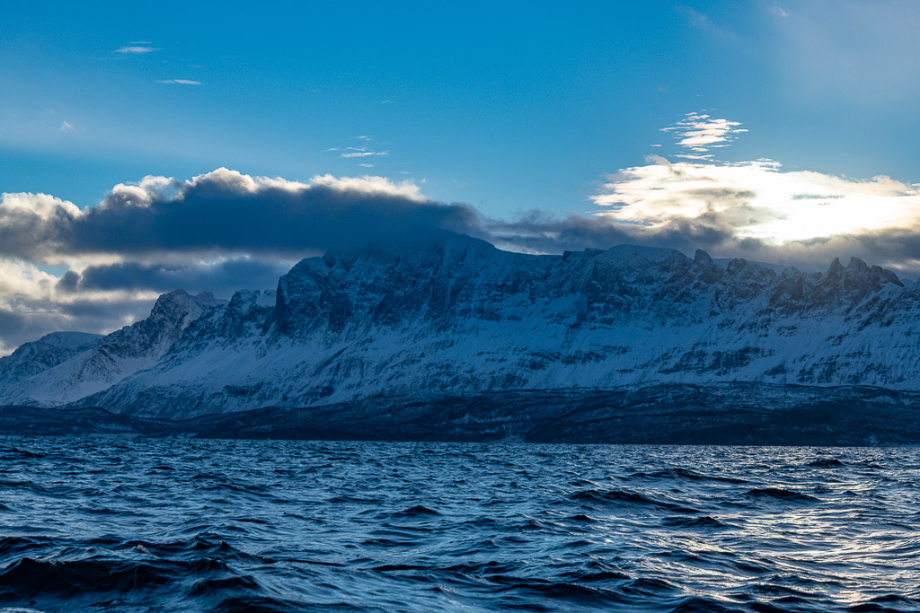 Longue crête enneigée sous un ciel bleu et un banc de nuages, Kvænangen, Troms, Norvège