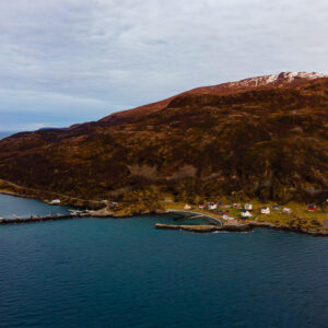 Aerial view of a village pier and houses at the foot of a hill, Seglvik, Troms, Norway