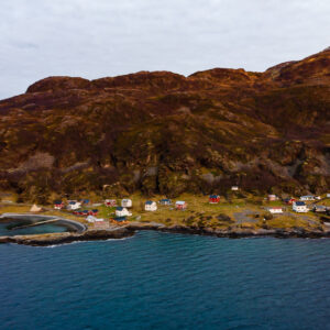 Vue aérienne basse de maisons colorées bordant le rivage et la digue, Seglvik, Troms, Norvège