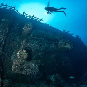 Diver over the superstructure and railing of a wreck, Maldives