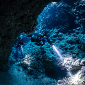 Rebreather diver exploring a wide cave chamber, Zabargad, Red Sea, Egypt