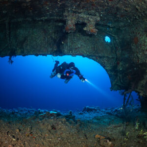 Rebreather diver passing beneath the hull of the Levanzo wreck, Red Sea, Egypt
