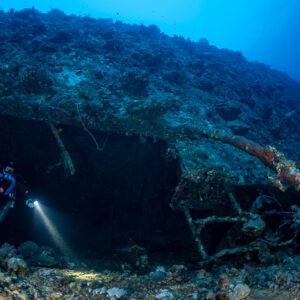 Rebreather diver with torch under the hull of the Levanzo wreck, Red Sea, Egypt