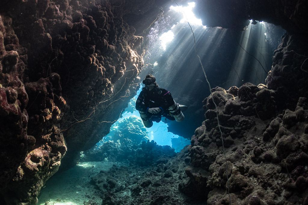 Rebreather diver passing a cave window with guideline, Gota Jeny, Red Sea, Egypt