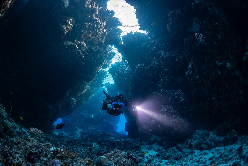 Plongeur en recycleur, lampe puissante, dans le passage principal de la grotte, Saint John's Cave, mer Rouge, Égypte