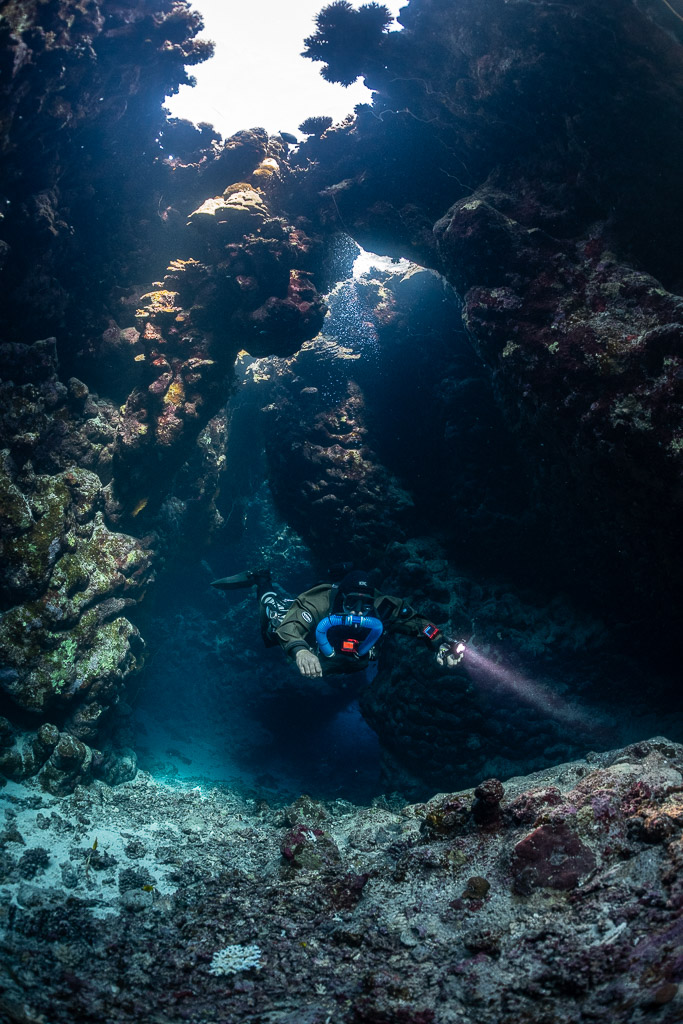 Rebreather diver below a skylight in the cave, Saint John's Cave, Red Sea, Egypt