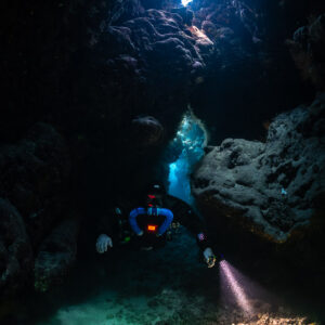 Rebreather diver coming towards the camera through the cave, Saint John's Cave, Red Sea, Egypt