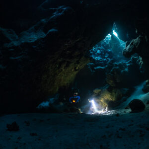 Small rebreather diver beneath a huge cave arch, Saint John's Cave, Red Sea, Egypt