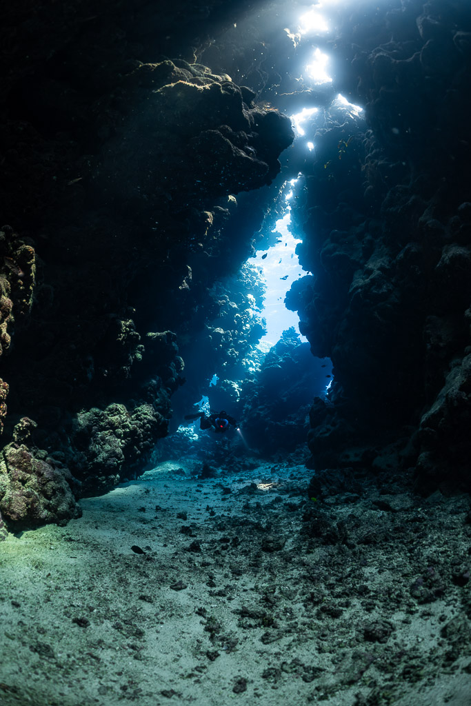 Light-filled cave fissure of Sha'ab Claudio, no diver, Sha'ab Claudio, Red Sea, Egypt