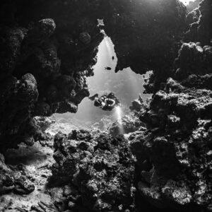 Rebreather diver in a cave window, black and white, Sha'ab Claudio, Red Sea, Egypt