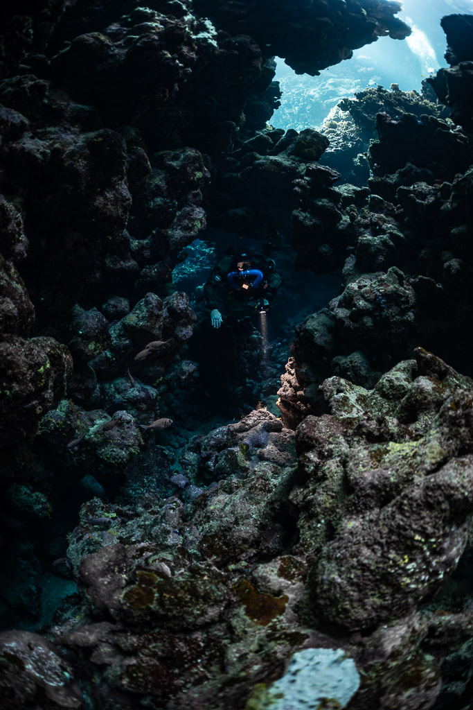 Rebreather diver deep in a dark cave passage, Sha'ab Claudio, Red Sea, Egypt