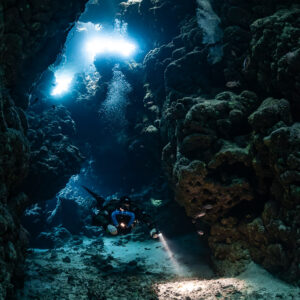 Rebreather diver at the bottom of a chimney of light, Sha'ab Claudio, Red Sea, Egypt