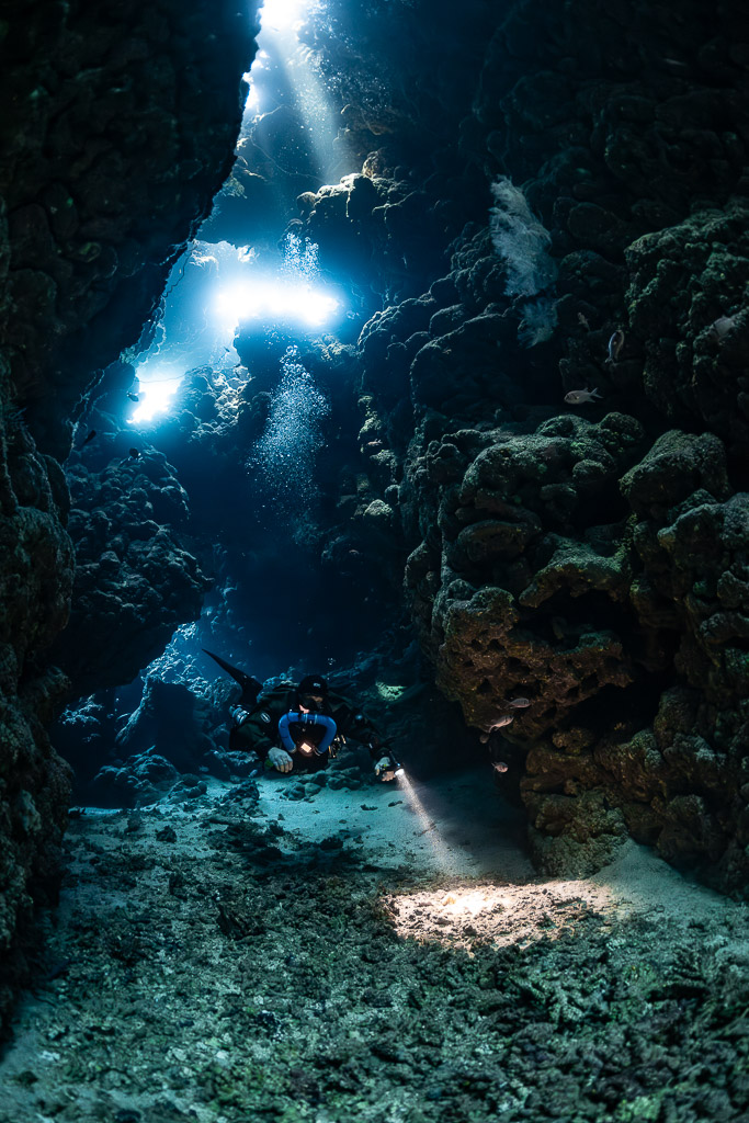 Rebreather diver at the bottom of a chimney of light, Sha'ab Claudio, Red Sea, Egypt