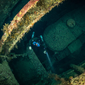 Rebreather diver in the hold of the Numidia wreck beneath a beam, Big Brother, Red Sea, Egypt