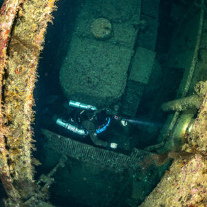 Rebreather diver deep inside the Numidia wreck, framed by the hull, Big Brother, Red Sea, Egypt