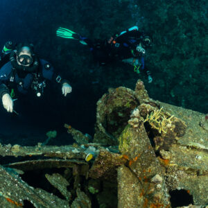 Rebreather diver facing the camera above encrusted wreck machinery, Red Sea, Egypt