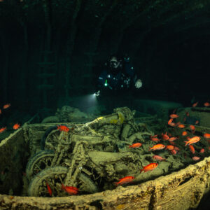 Rebreather diver behind a truck bed of motorcycles and soldierfish, Thistlegorm wreck, Red Sea, Egypt