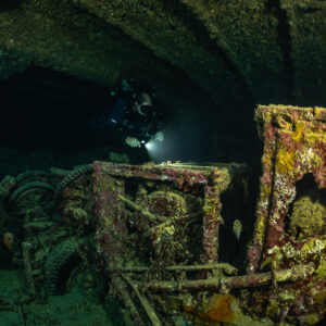 Rebreather diver behind an encrusted truck frame in a hold, Thistlegorm wreck, Red Sea, Egypt