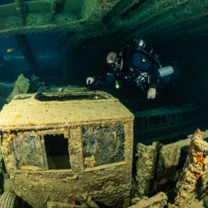 Rebreather diver above an encrusted truck cab in a cargo hold, Thistlegorm wreck, Red Sea, Egypt