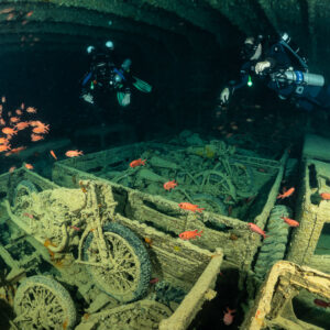Two rebreather divers above motorcycles in truck beds with soldierfish, Thistlegorm wreck, Red Sea, Egypt