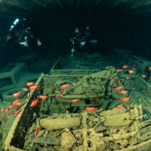 Benne de motos dans une cale avec poissons-soldats et plongeurs, plan plus large, épave du Thistlegorm, mer Rouge, Égypte