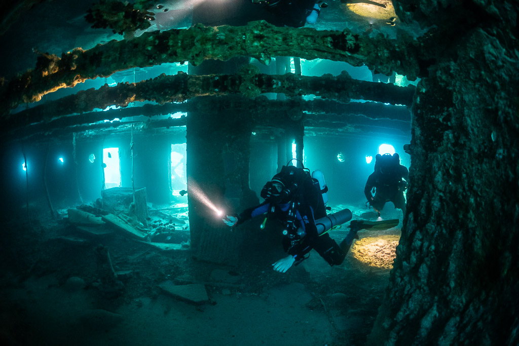 Rebreather diver among wreck pillars with a second diver beyond, Thistlegorm wreck, Red Sea, Egypt