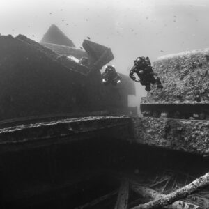 Black-and-white shot of a diver beside a wreck superstructure, Thistlegorm wreck, Red Sea, Egypt