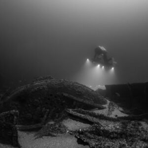Black and white rebreather diver lighting broken wreck plates with photogrammetry rig, Saint-Malo, Brittany, France