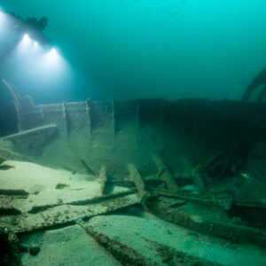Diver with photogrammetry lights above wreck hull side and frames, Saint-Malo, Brittany, France